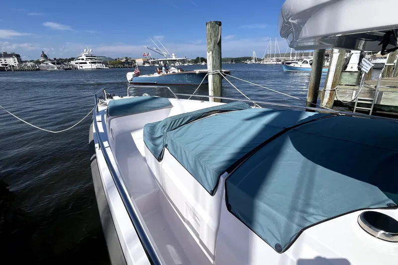 Slide: The Image of 2023 Axopar 37 XC Cross Cabin docked at marina with blue covers. - 49