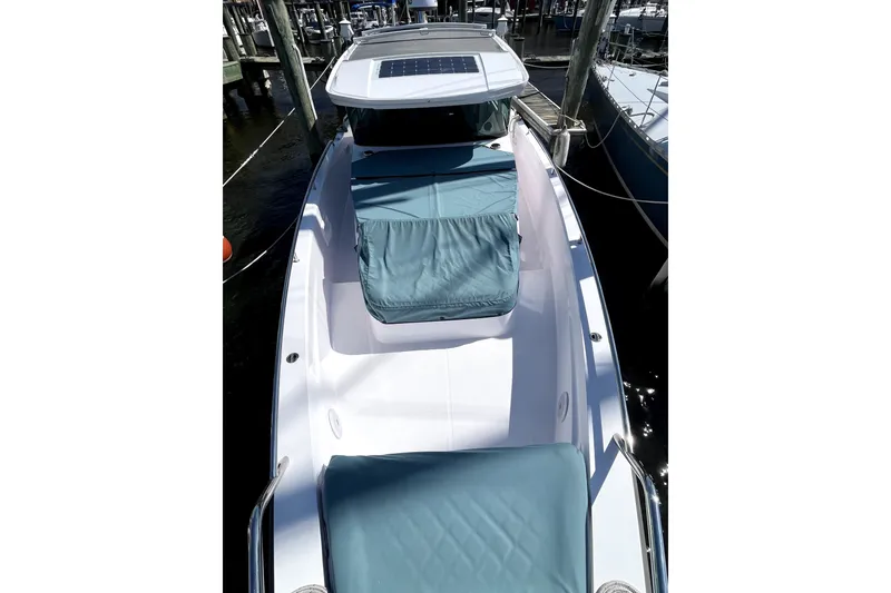 Slide: The Image of 2023 Axopar 37 XC Cross Cabin boat docked, featuring sleek design and cushioned seating. - 48