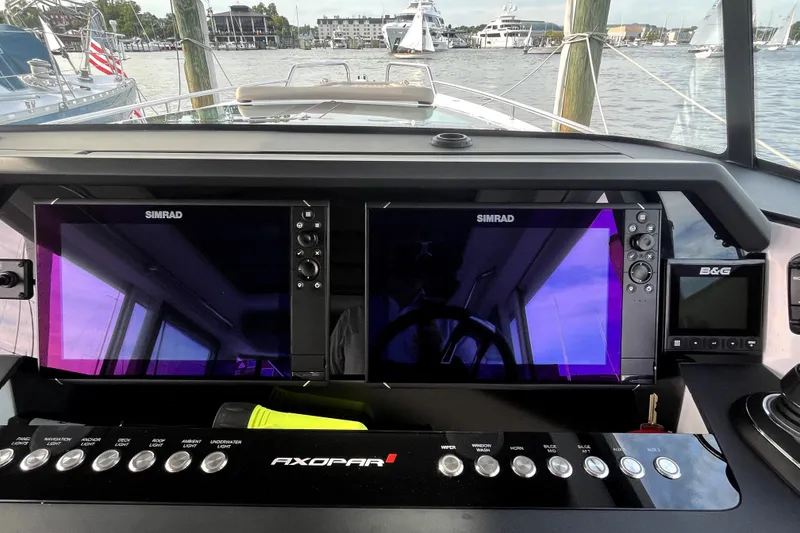 Slide: The Image of 2023 Axopar 37 XC Cross Cabin dashboard with dual Simrad displays and control panel. - 16