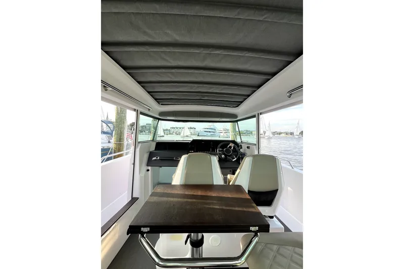 Slide: The Image of Interior of 2023 Axopar 37 XC Cross Cabin, featuring modern seating and steering wheel. - 13