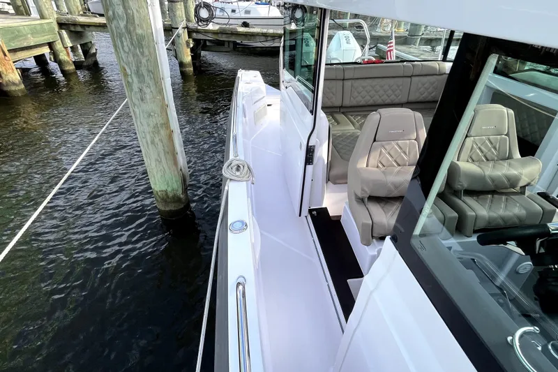 Slide: The Image of 2023 Axopar 37 XC Cross Cabin boat docked, featuring luxurious seating and sleek design. - 32