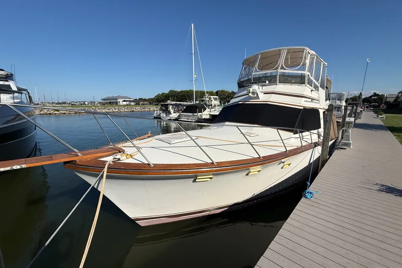 The Image of 1984 Egg Harbor 40 Sedan yacht docked at marina under clear blue sky. - 0