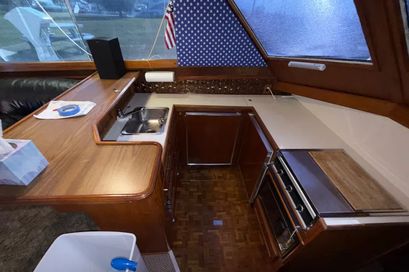 Slide: The Image of 1984 Egg Harbor 40 Sedan yacht interior kitchen with wood cabinetry and stainless steel sink. - 19