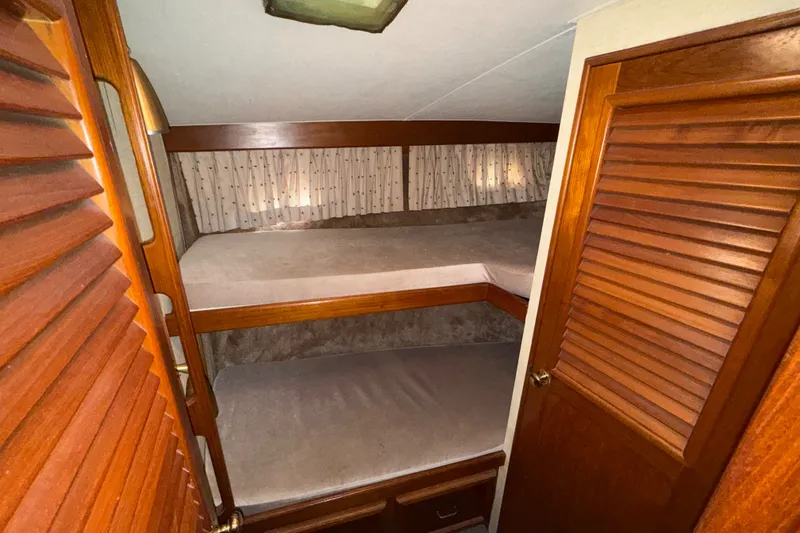 Slide: The Image of Interior of 1984 Egg Harbor 40 Sedan with wooden bunk beds and cozy lighting. - 23