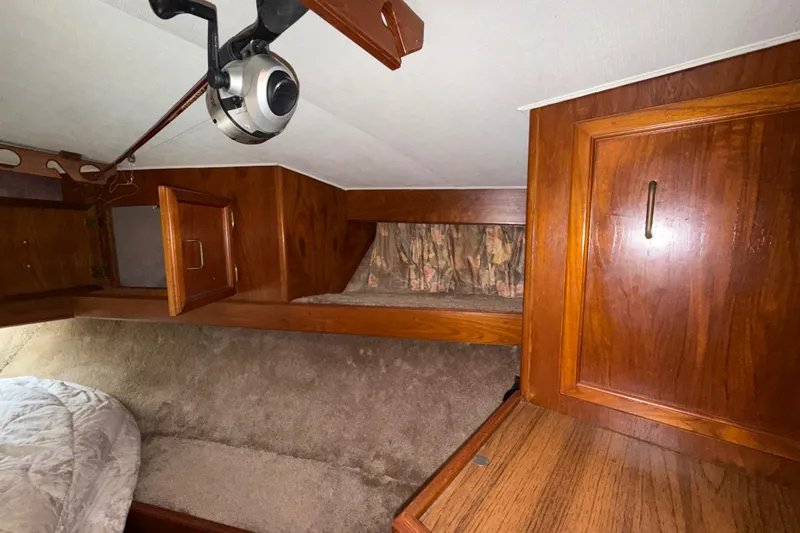Slide: The Image of Interior cabin of 1984 Egg Harbor 40 Sedan with wooden cabinetry and cozy bedding. - 24
