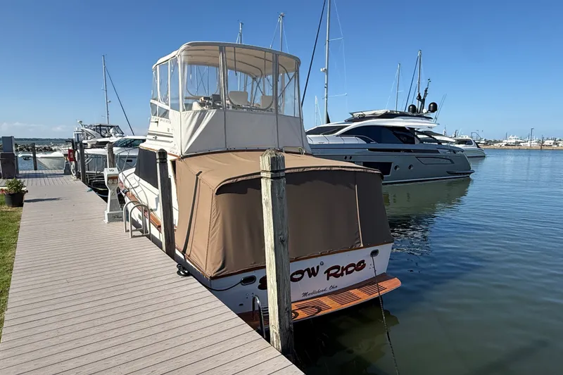 Slide: The Image of 1984 Egg Harbor 40 Sedan docked at marina, clear sky, calm water. - 4