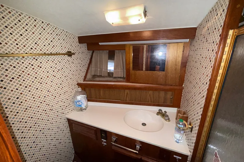 Slide: The Image of 1984 Egg Harbor 40 Sedan bathroom with mosaic tiles, wooden cabinetry, and sink. - 25