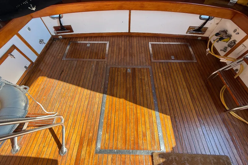 Slide: The Image of 1984 Egg Harbor 40 Sedan boat deck with polished wood finish and storage hatches. - 11