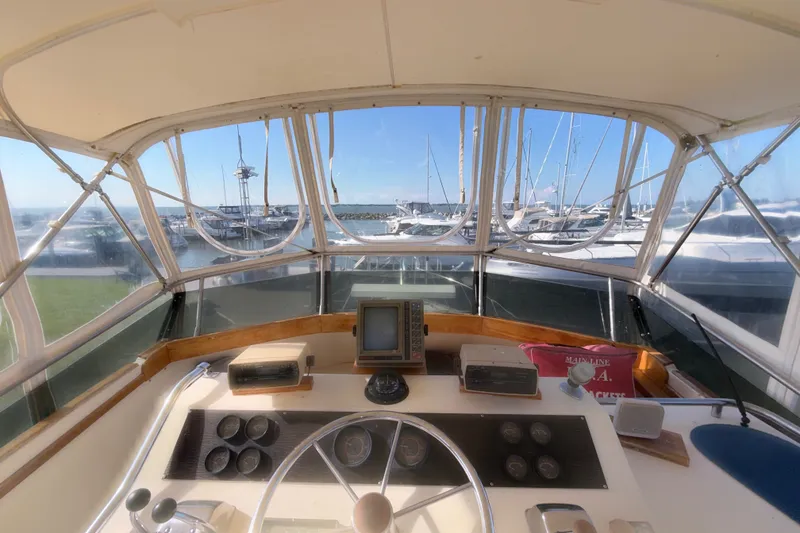 Slide: The Image of Cockpit view of 1984 Egg Harbor 40 Sedan yacht with marina in background. - 28