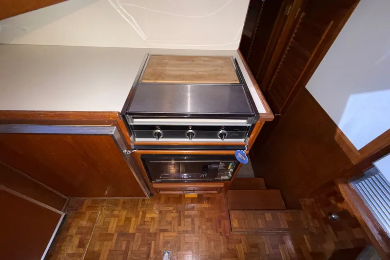 Slide: The Image of 1984 Egg Harbor 40 Sedan kitchen area with stove and wooden cabinetry. - 20