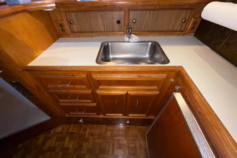 Slide: The Image of 1984 Egg Harbor 40 Sedan kitchen with wooden cabinets and stainless steel sink. - 22