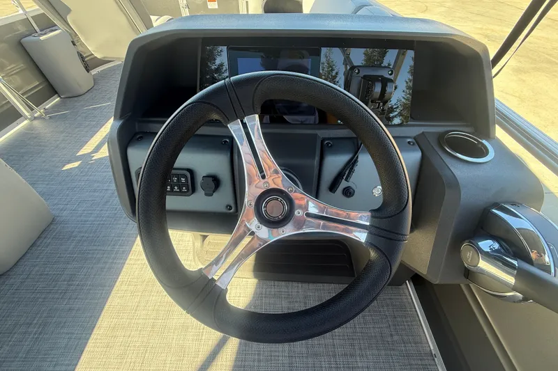 Slide: The Image of Steering wheel of 2027 Sun Tracker SportFish 20 DLX boat, featuring modern dashboard controls. - 19