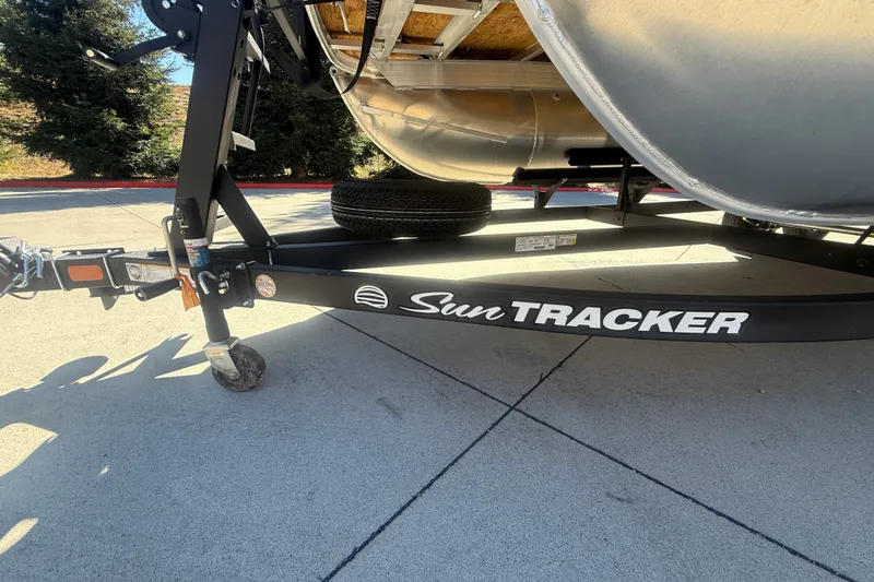 Slide: The Image of 2027 Sun Tracker SportFish 20 DLX trailer on pavement, showcasing brand logo. - 57