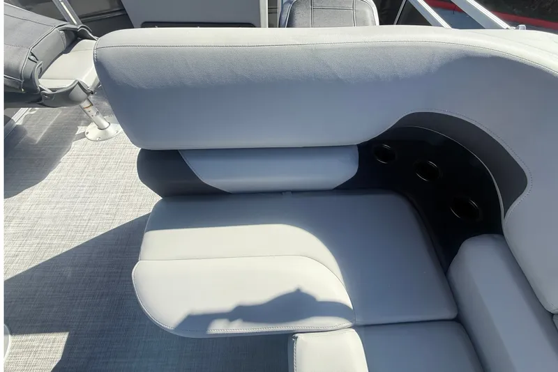 Slide: The Image of 2027 Sun Tracker SportFish 20 DLX boat seating with cup holders, featuring gray upholstery. - 34