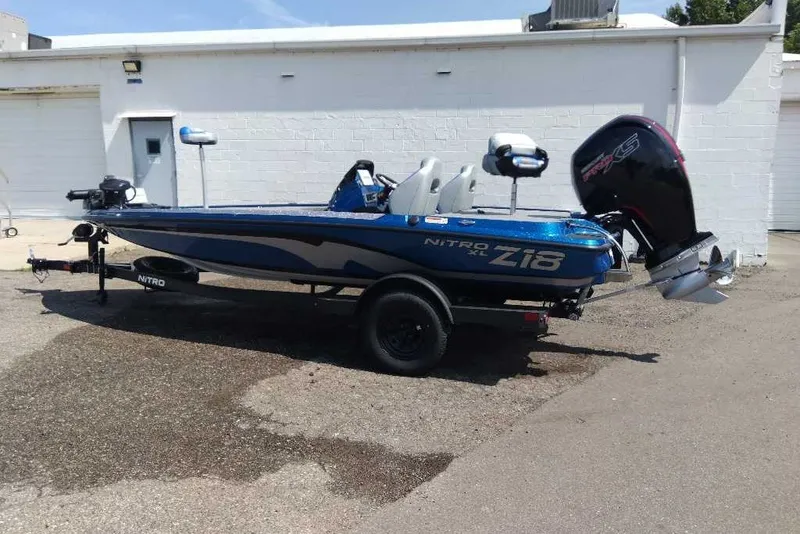 Slide: The Image of 2027 Nitro Z18 XL Pro boat with motor, parked on a trailer outside a building. - 3