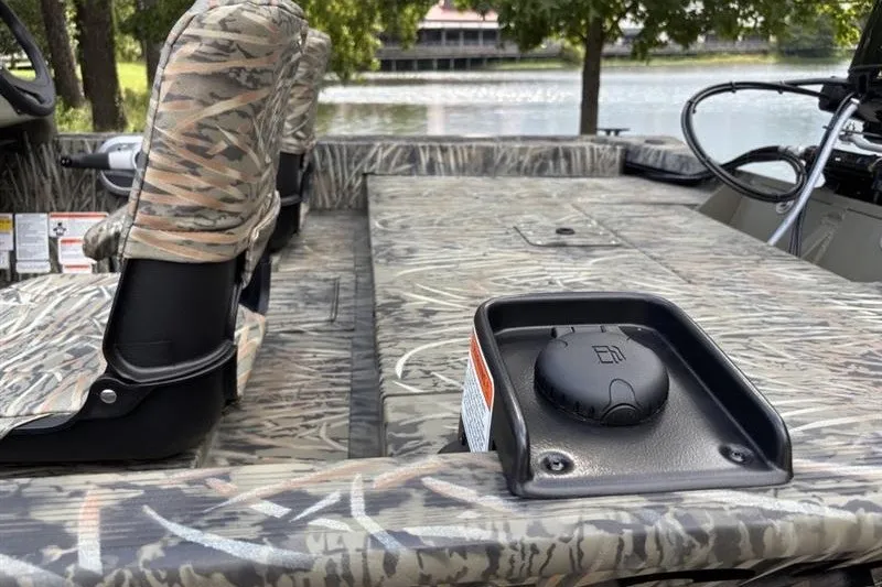 Slide: The Image of 2027 Tracker Grizzly 1754 SC boat interior with camouflage seating and lake view. - 13