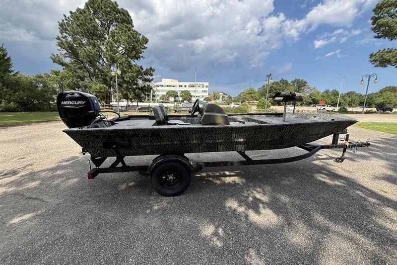 Slide: The Image of 2027 Tracker Grizzly 1754 SC boat on trailer, parked outdoors under cloudy sky. - 15