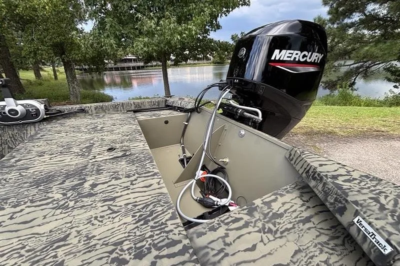 Slide: The Image of 2027 Tracker Grizzly 1648 SC boat with Mercury engine by a serene lake. - 16