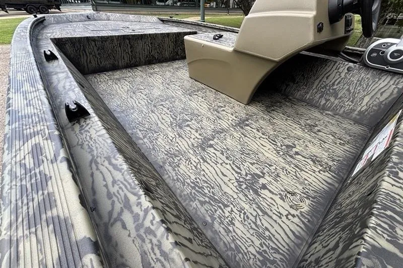 Slide: The Image of 2027 Tracker Grizzly 1648 SC boat interior with camouflage pattern and steering console. - 13