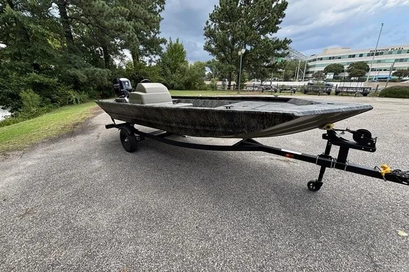 Slide: The Image of 2027 Tracker Grizzly 1648 SC boat on trailer in a park setting. - 17