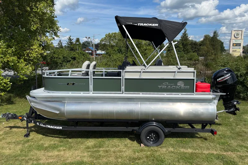 The Image of 2027 Sun Tracker Bass Buggy 16 XL Select pontoon boat on trailer, outdoors. - 0