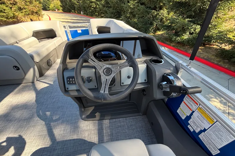 Slide: The Image of 2027 Sun Tracker SportFish 22 DLX boat interior with steering wheel and seating area. - 22