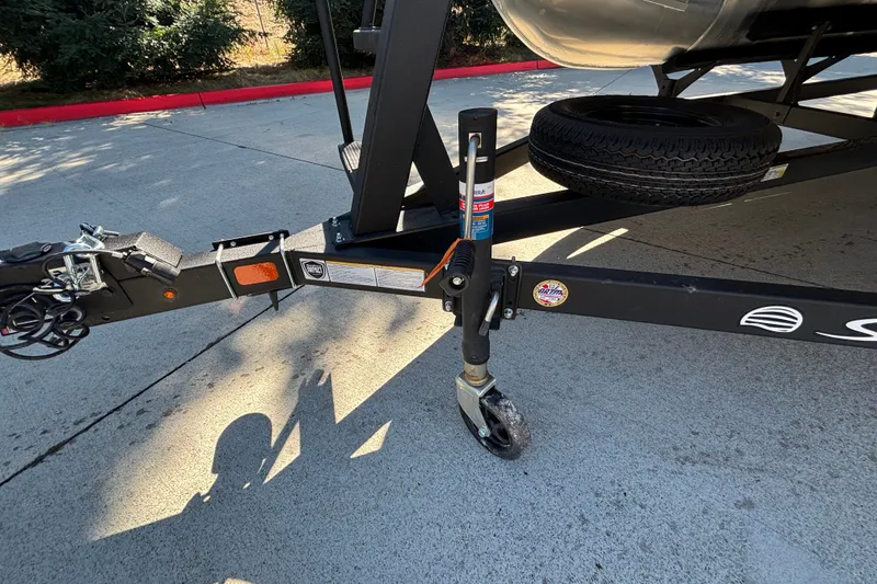 Slide: The Image of Trailer hitch and wheel of 2027 Sun Tracker SportFish 22 DLX on concrete surface. - 63