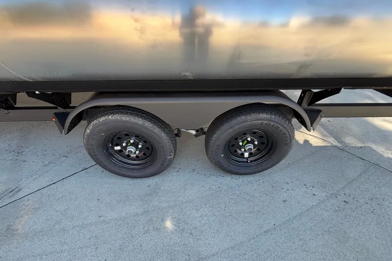 Slide: The Image of Trailer wheels of 2027 Sun Tracker SportFish 22 DLX on concrete surface. - 66