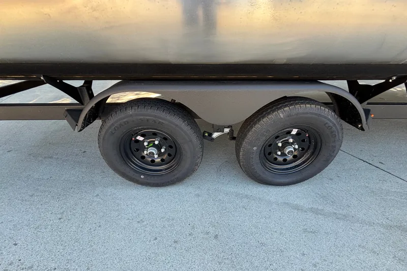 Slide: The Image of Trailer wheels of a 2027 Sun Tracker SportFish 22 DLX on concrete surface. - 61