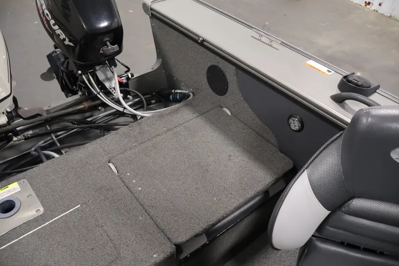 Slide: The Image of 2013 Lund 1750 Tyee boat interior with Mercury engine, featuring gray seating and carpeted flooring. - 43
