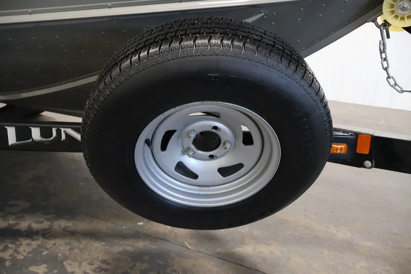Slide: The Image of 2013 Lund 1750 Tyee trailer wheel with black tire and silver rim. - 51