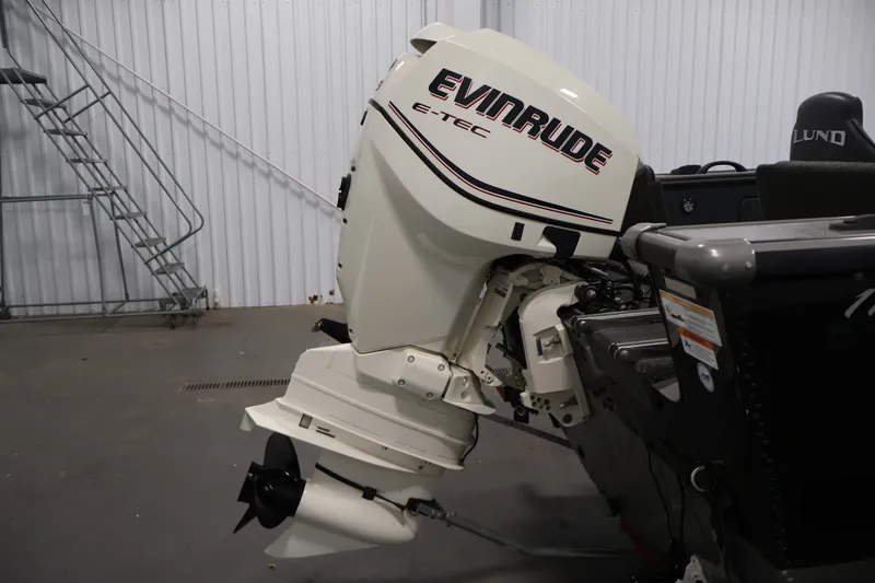 Slide: The Image of 2013 Lund 1750 Tyee boat with Evinrude E-TEC outboard motor in a garage. - 44