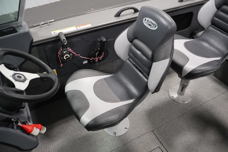 Slide: The Image of Interior of a 2013 Lund 1750 Tyee boat featuring two cushioned seats and steering wheel. - 27