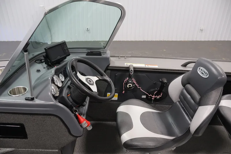 Slide: The Image of 2013 Lund 1750 Tyee boat interior with steering wheel, dashboard, and seating. - 55