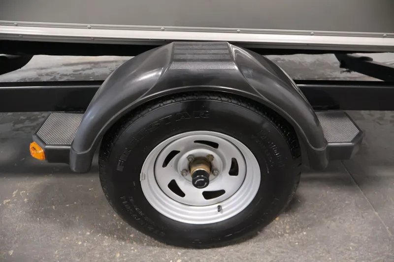 Slide: The Image of Trailer wheel of 2013 Lund 1750 Tyee boat, featuring black fender and step. - 53