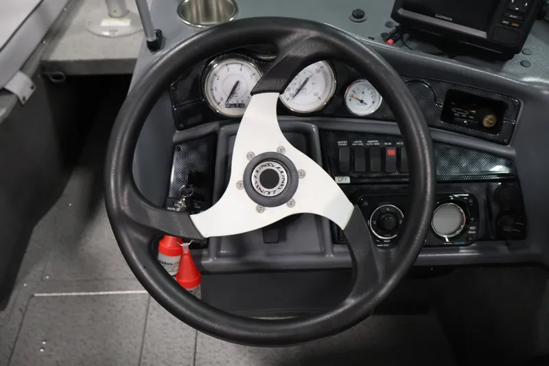 Slide: The Image of Steering wheel and dashboard of 2013 Lund 1750 Tyee boat with gauges and controls. - 57