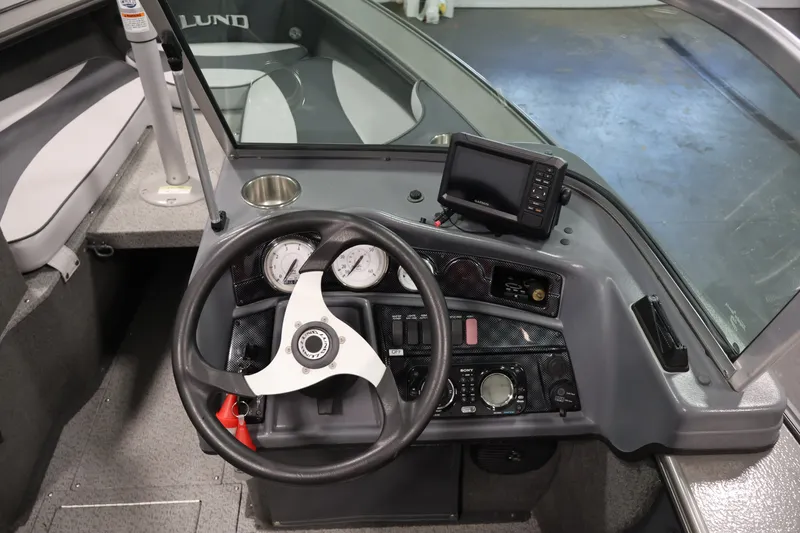 Slide: The Image of 2013 Lund 1750 Tyee boat dashboard with steering wheel and navigation system. - 56