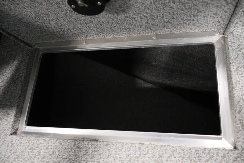 Slide: The Image of Storage compartment in 2013 Lund 1750 Tyee boat, featuring a carpeted interior. - 18