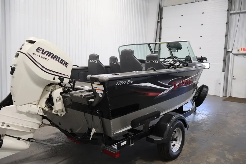 Slide: The Image of 2013 Lund 1750 Tyee boat with Evinrude E-TEC engine in a garage setting. - 54
