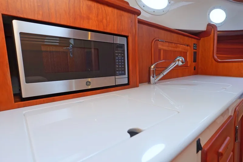 Slide: The Image of Modern galley kitchen in 2022 Hinckley 35 yacht with microwave and sleek countertop. - 13