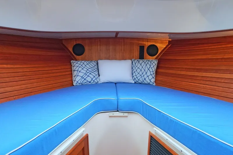 Slide: The Image of Interior cabin of 2022 Hinckley 35 boat with blue cushions and wooden paneling. - 15