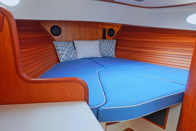 Slide: The Image of Cozy cabin interior of 2022 Hinckley 35 yacht with blue cushions and wooden paneling. - 16