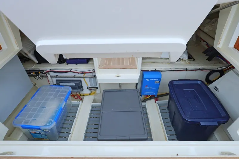 Slide: The Image of Storage compartment of a 2022 Hinckley 35 boat with organized containers and equipment. - 20