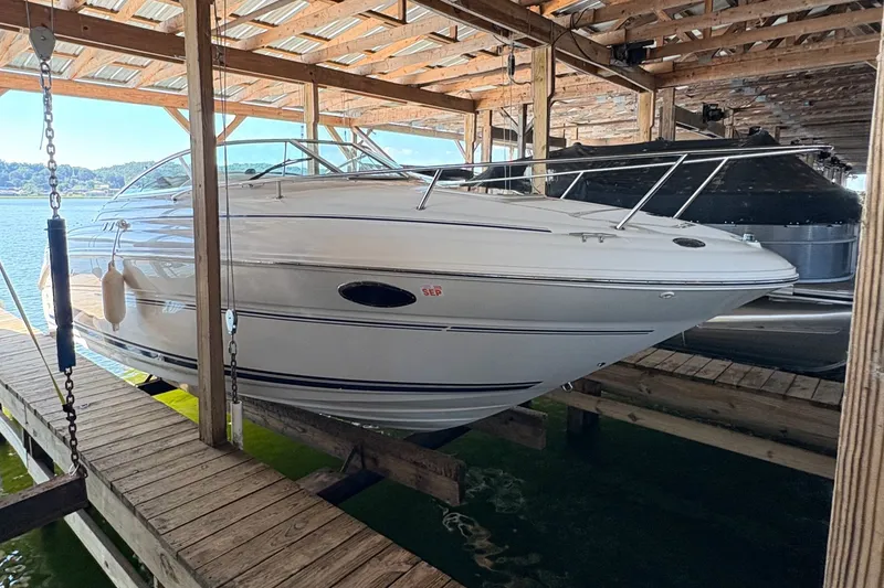 The Image of 2000 Sea Ray 245 Weekender boat docked in a covered marina. - 0