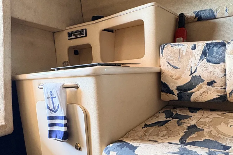Slide: The Image of Interior of a 2000 Sea Ray 245 Weekender boat with nautical-themed decor. - 16