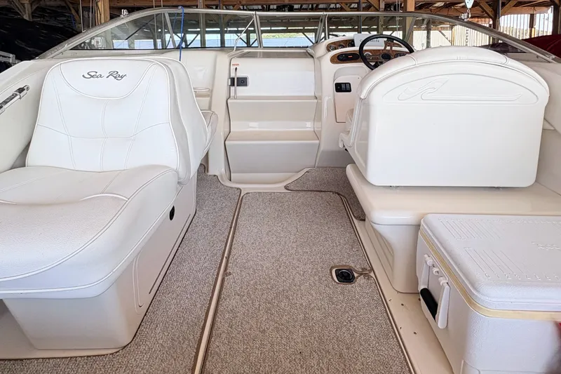 Slide: The Image of Interior of a 2000 Sea Ray 245 Weekender boat with white seating and dashboard. - 14