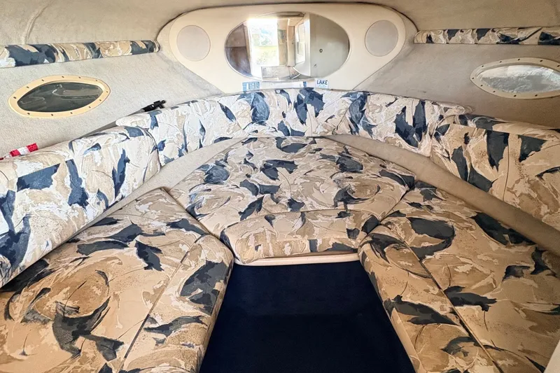 Slide: The Image of Interior of 2000 Sea Ray 245 Weekender boat with patterned seating and porthole windows. - 17