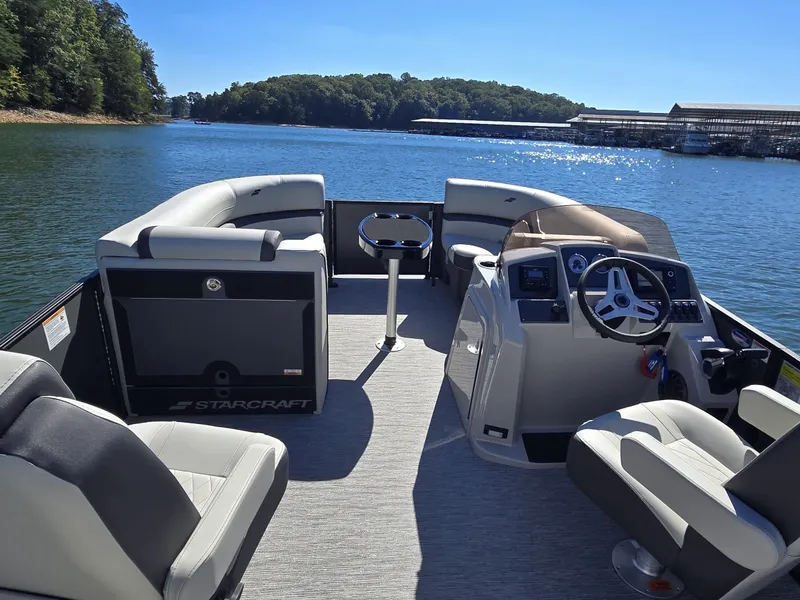 Slide: The Image of Starcraft EX 20 Q DH pontoon boat from 2027 on a calm lake with a modern cockpit. - 14