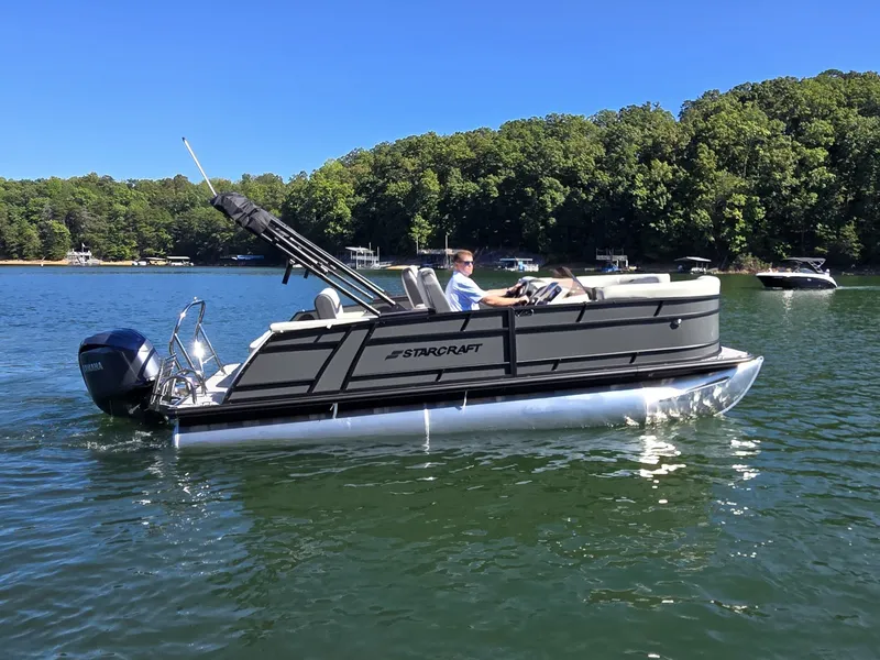 Slide: The Image of Starcraft EX 20 Q DH pontoon boat from 2027 on a calm lake with wooded shoreline. - 4