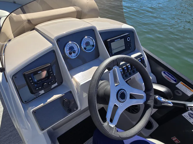 Slide: The Image of The image shows the helm of a Starcraft EX 20 Q DH boat. It features a modern steering wheel, gauges, and a display. - 20